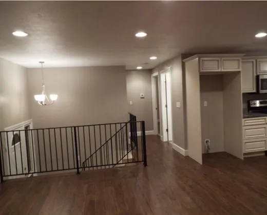 Finished basement with new flooring, railing, and kitchenette