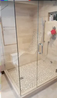Frameless glass shower with pebble tile floor