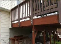 Aging elevated deck with worn railing before rebuild
