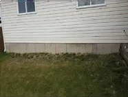 Bare backyard siding before deck build