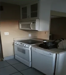 Original kitchen stove wall with dated appliances before remodel