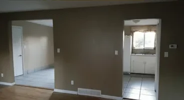 Empty main floor with dated paint and flooring before remodel